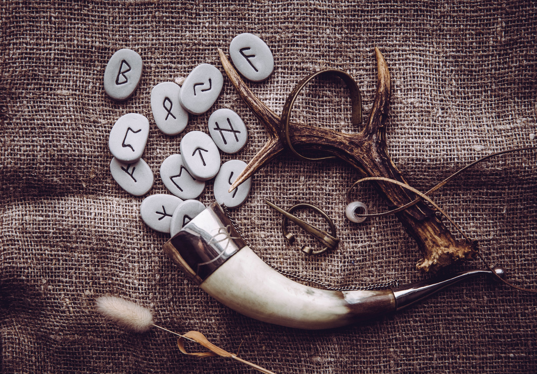 Flat lay view of rune stones with various viking era style objects. Ancient divination and vikings lifestyle concept.